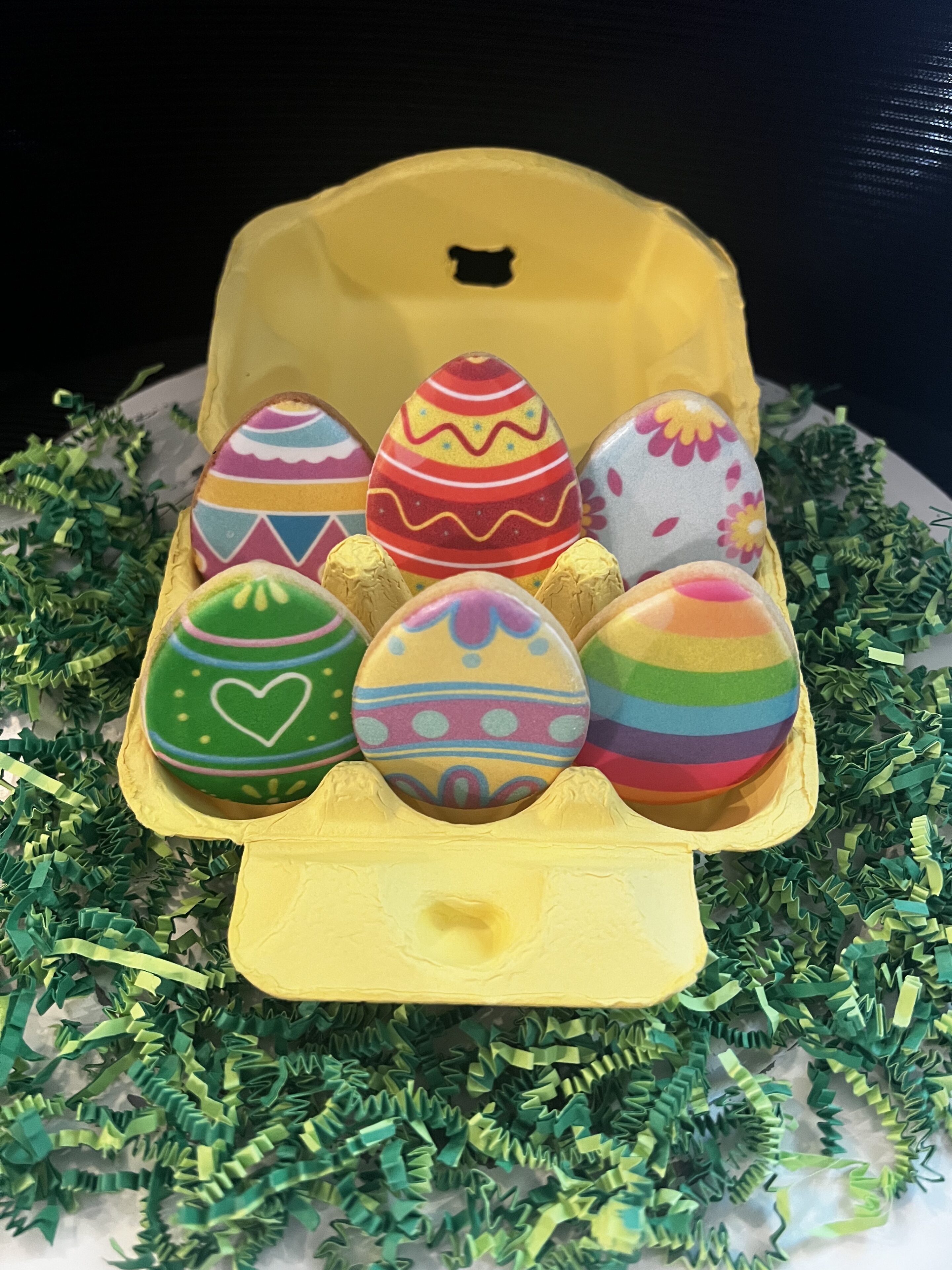 Colorful Easter eggs in a yellow carton.