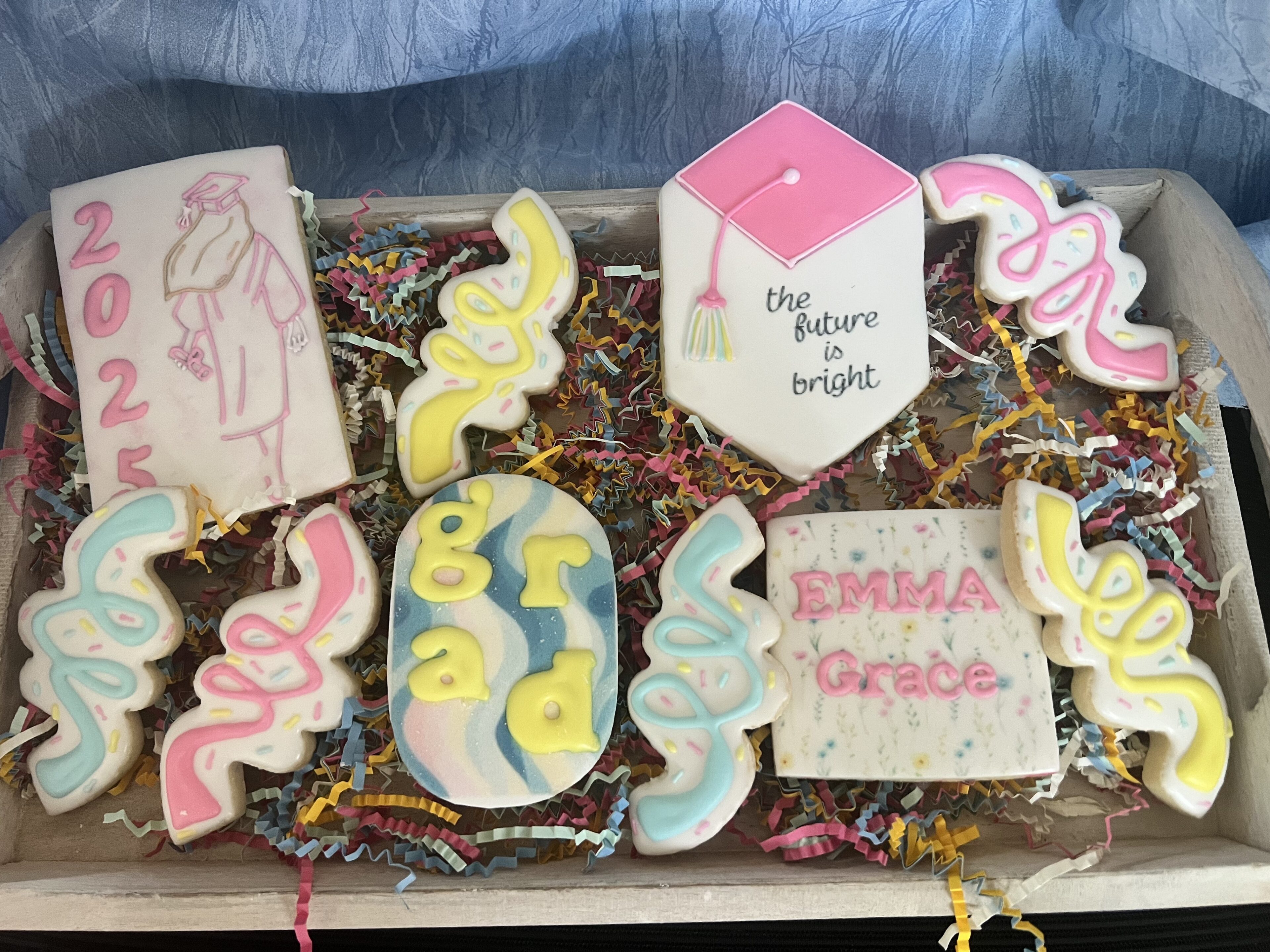 Decorative graduation-themed cookies in a box.